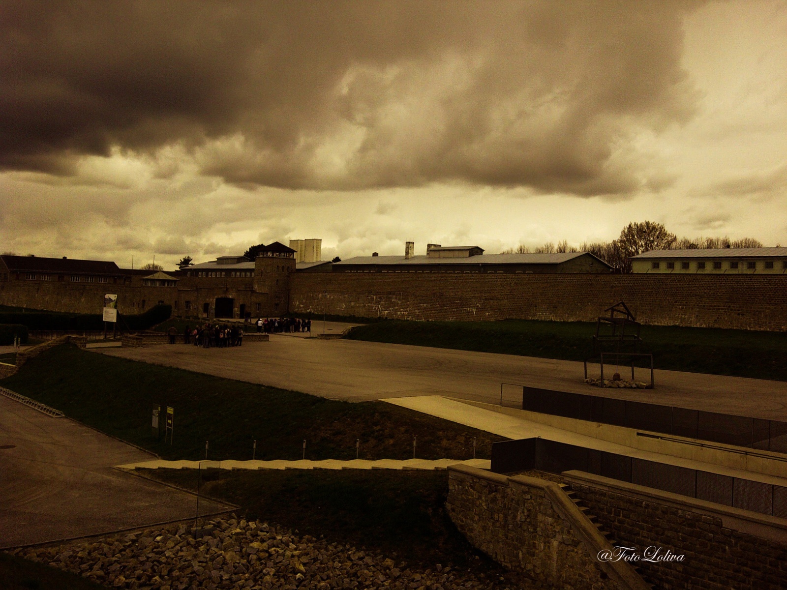 MAUTHAUSEN - IL CAMPO - Il campo di concentramento di Mauthausen, denominato campo di concentramento di Mauthausen-Gusen dall'estate del 1940, era un lager nazista, una fortezza in pietra eretta nel 1938 in cima a una collina sovrastante la piccola cittadina di Mauthausen, nell'allora Gau Oberdonau, ora Alta Austria, situata a circa venticinque chilometri a est di Linz.
Mauthausen, costruito con il granito della sottostante cava, era una estesa fortezza di pietra in uno stile vagamente orientale, tanto che l'ingresso principale al lager era chiamato dai prigionieri "La Porta mongola". La fortezza, di pianta rettangolare, era chiusa su tre lati da mura di pietra spesse due metri e alte fino a otto. Il lato del lager che non si riuscì a finire fu chiuso da un reticolato di filo spinato percorso da corrente elettrica ad alta tensione, luogo di numerosi suicidi.
Considerato impropriamente come semplice campo di lavoro, fu di fatto, fra tutti i campi nazisti, «il solo campo di concentramento classificato di "classe 3" (come campo di punizione e di annientamento attraverso il lavoro)». Vi si attuò lo sterminio soprattutto attraverso il lavoro forzato nella vicina cava di granito e la consunzione per denutrizione e stenti, pur essendo presenti anche alcune piccole camere a gas.
